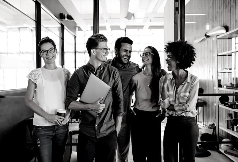 Women and men staff laughing in a hallway